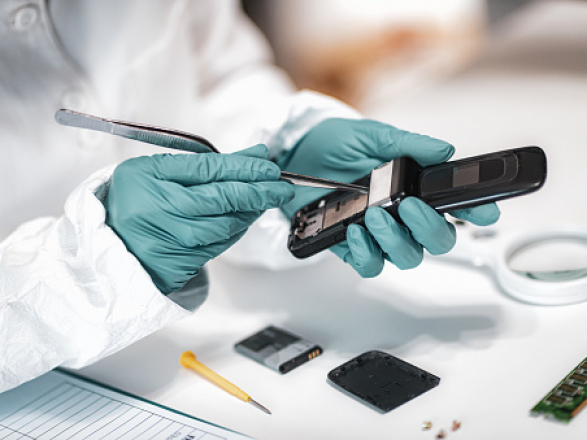 Digital Forensic Science. Police Forensic Analyst Examining Confiscated Mobile Phone.